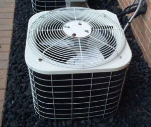 Air conditioner outside a home surrounded by rocks